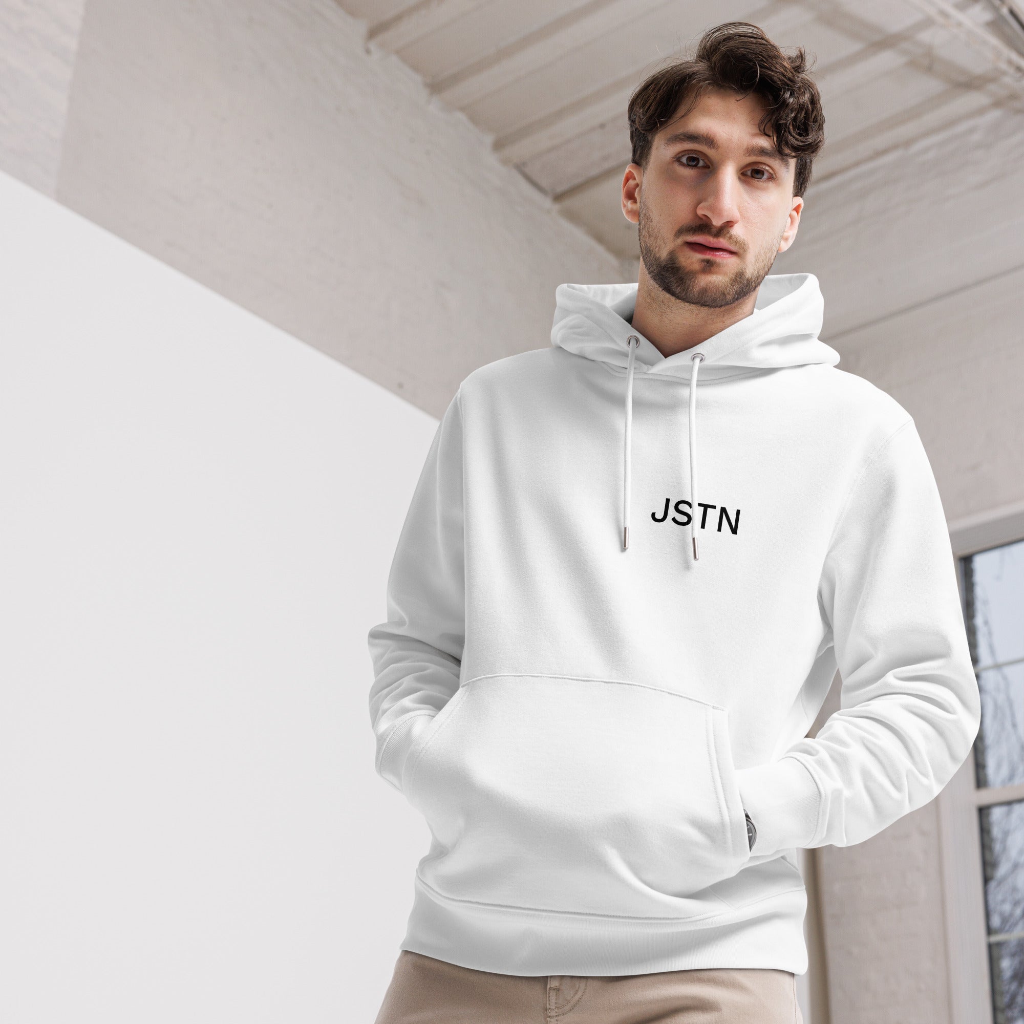 Unisex Hoodie Weiß JSTN Frontansicht – Model indoor